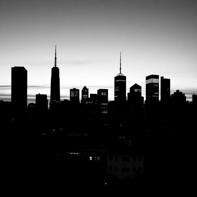 A striking black and white view of Manhattan Island from across the Hudson River, highlighting its distinctive skyline featuring iconic skyscrapers.