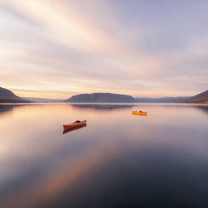 A serene view at dusk with boats on the calm water, perfect for a peaceful moment or a tranquil escape.