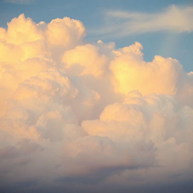 A picturesque cloudy sky with radiant hues of orange and pink, creating a serene backdrop. Capture the beauty of nature with this vibrant wallpaper.