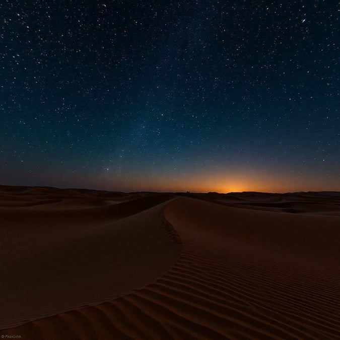 A captivating view of the night sky over a desert landscape, evoking the serenity and spirituality associated with the holy month of Ramadan. The vast expanse of sand dunes under the starry sky is a testament to the tranquility and isolation often sought during this sacred time. Celebrate the end of Ramadan and Eid with this breathtaking desert wallpaper.